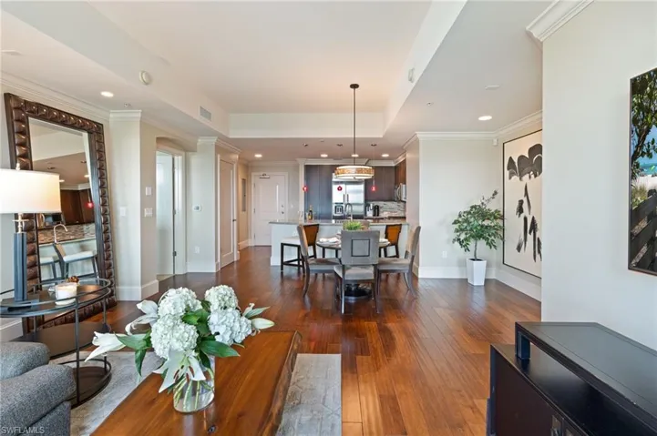 Living room with crown molding, dark wood-style flooring, and recessed lighting
