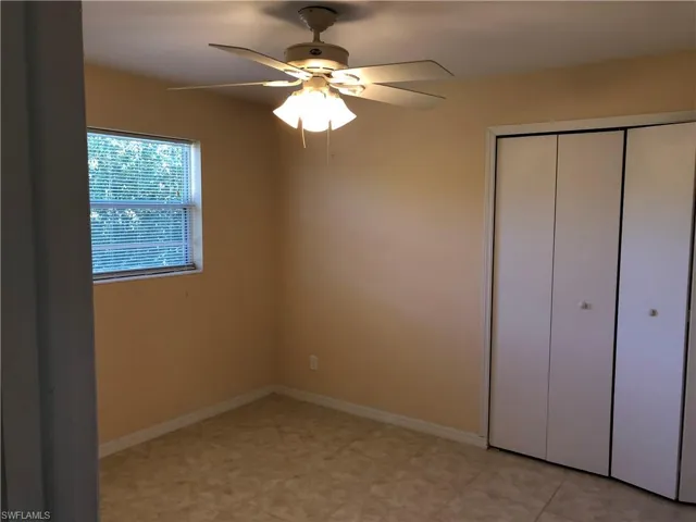 Bedroom featuring a closet, light tile floors, and ceiling fan