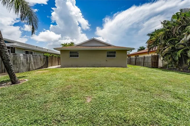 Rear view of property with stucco siding and a fenced backyard