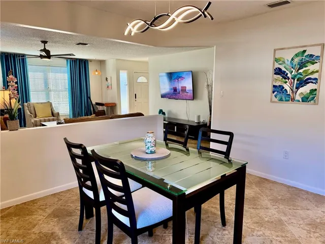 Dining room with a ceiling fan and a textured ceiling