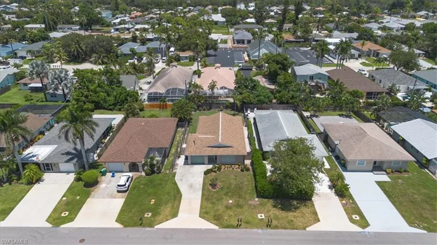 Aerial view of property and surrounding area featuring nearby suburban area