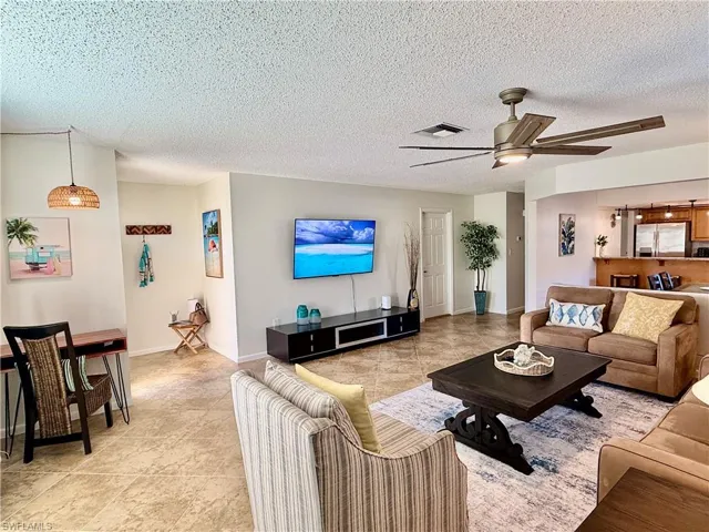 Living area with ceiling fan and a textured ceiling