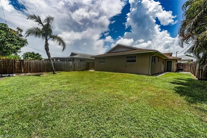 Back of house with stucco siding and a fenced backyard