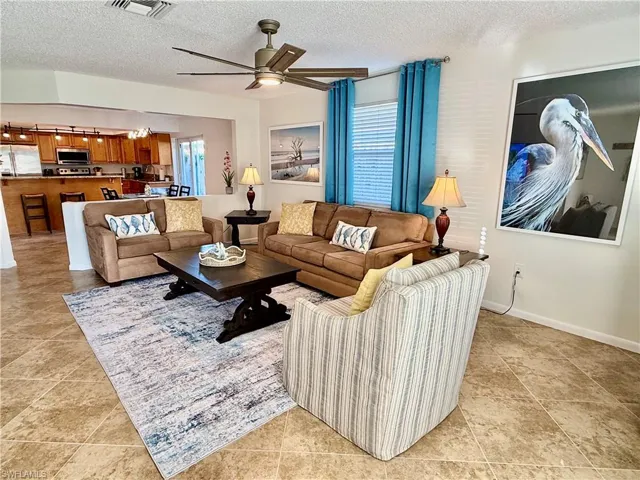 Living room with a textured ceiling and ceiling fan