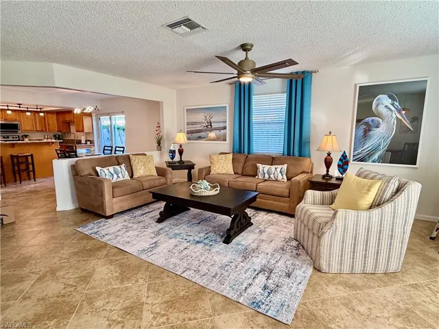 Living area with ceiling fan and a textured ceiling