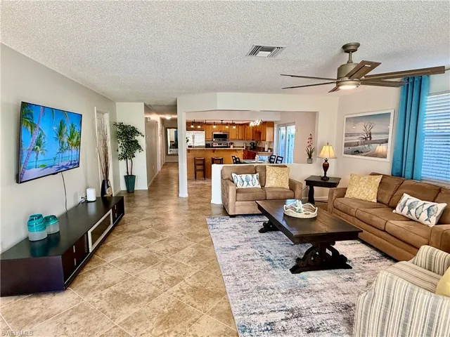 Living room with a textured ceiling and a ceiling fan