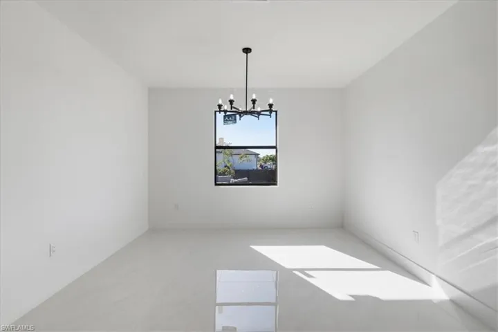 Spare room featuring suspended lighting and baseboards