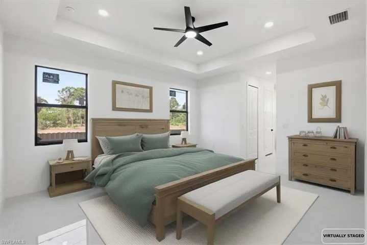 Bedroom with a raised ceiling, a ceiling fan, a closet, and recessed lighting