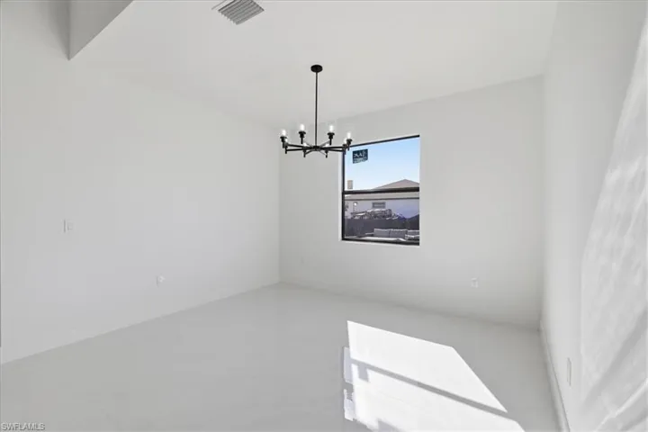 Empty room featuring hanging lights and concrete floors