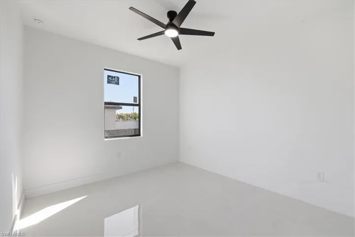 Unfurnished room with a ceiling fan and baseboards