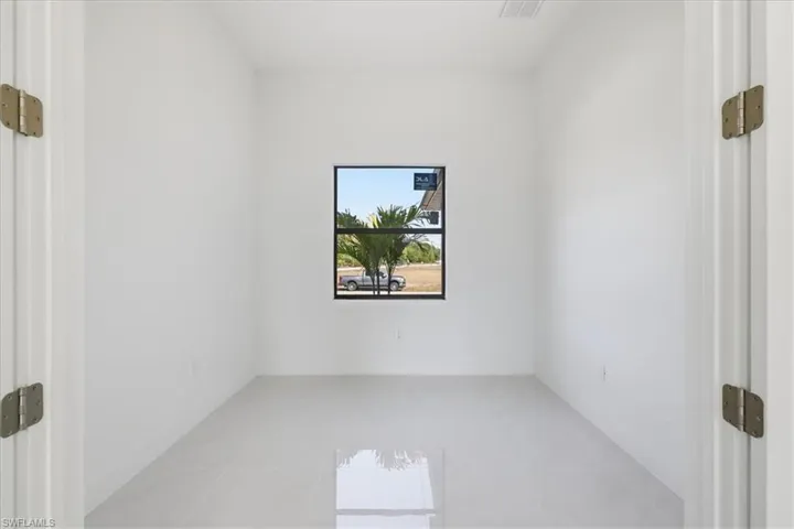 Empty room with baseboards and light tile patterned floors