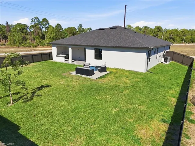 Back of property featuring an outdoor hangout area, a patio, a fenced backyard, stucco siding, and a shingled roof