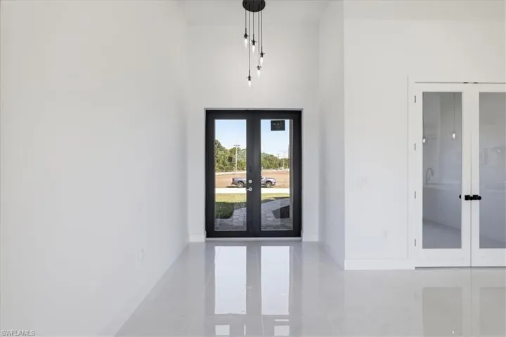 Entrance foyer with french doors, a high ceiling, and light tile patterned floors