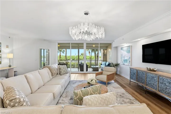 Living Room. Featuring a sparkling chandelier and hardwood flooring throughout the common areas.