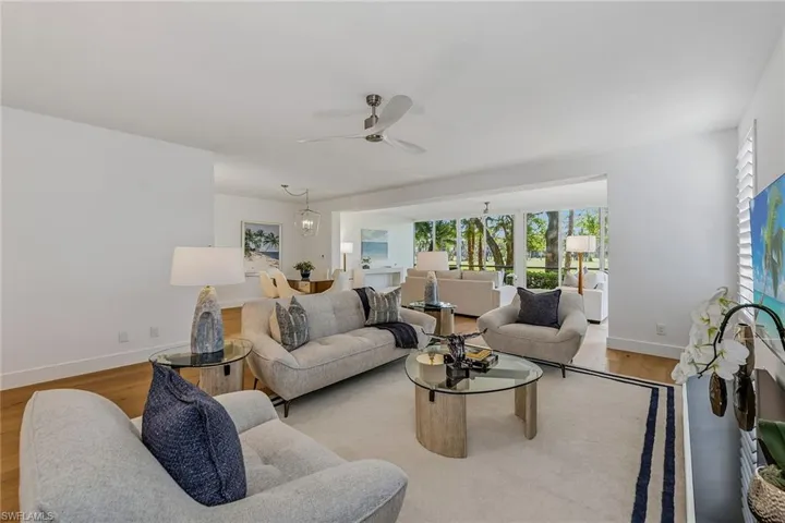 Living area with wood finished floors, ceiling fan, and a chandelier