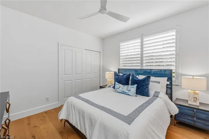 Bedroom with wood finished floors, a closet, and ceiling fan