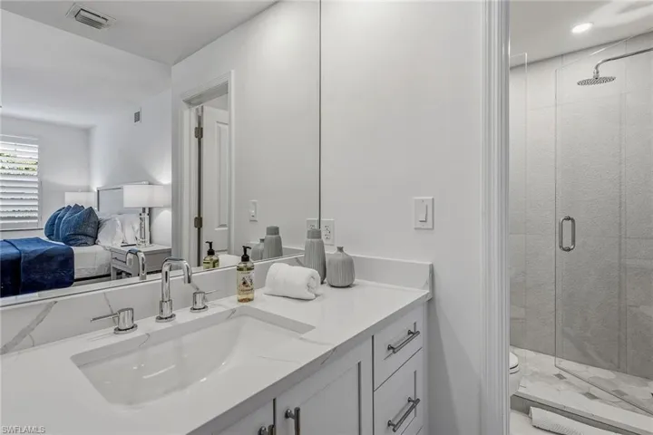 Ensuite bathroom featuring vanity and a stall shower