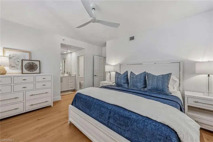 Bedroom featuring light wood-style floors, ensuite bath, and ceiling fan