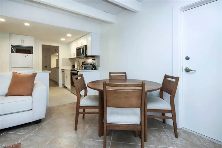 Dining space with light tile patterned floors, recessed lighting, and beamed ceiling