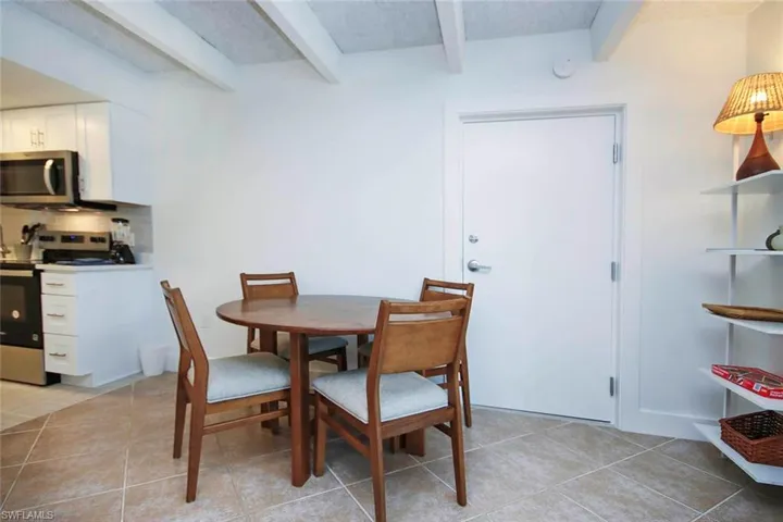 Dining room with beamed ceiling and light tile patterned floors