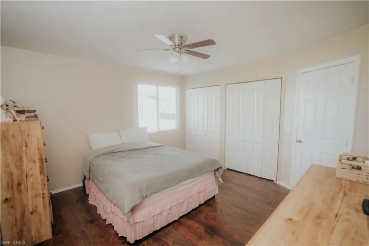 White paneled door, vanity with storage, octagonal wall mirror, and three-light fixture