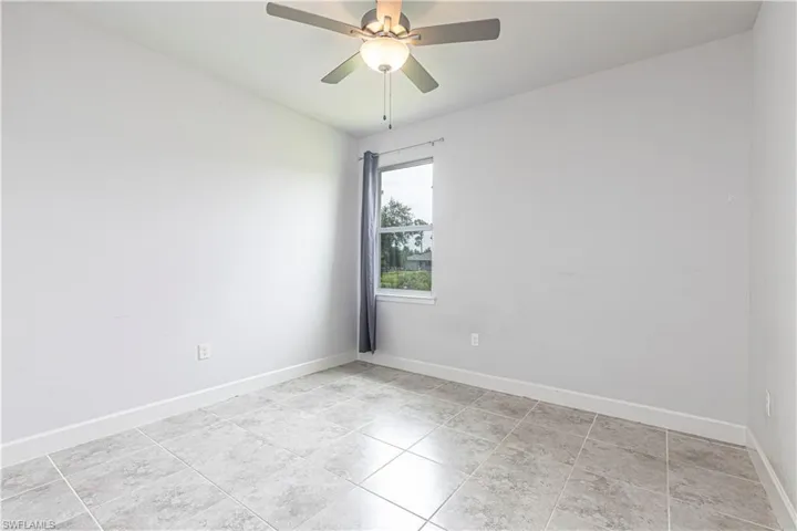Tiled spare room with ceiling fan