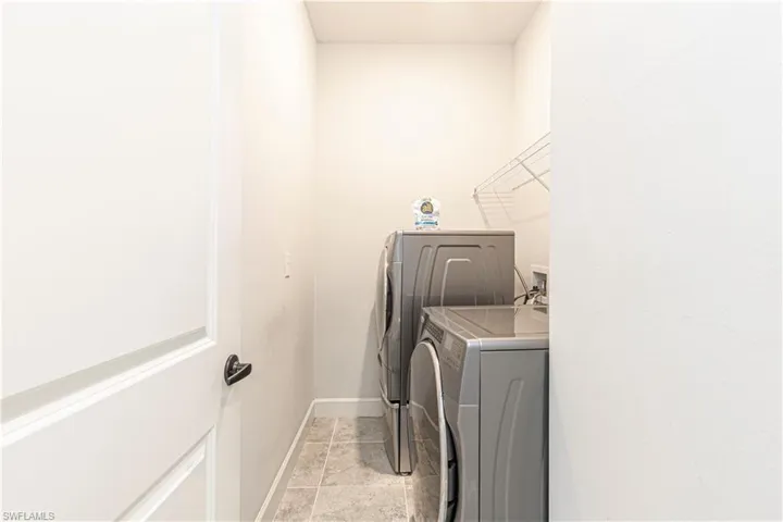 Laundry room featuring washer and dryer and light tile patterned floors