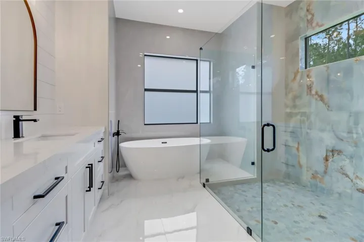 Bathroom featuring independent shower and bath and vanity