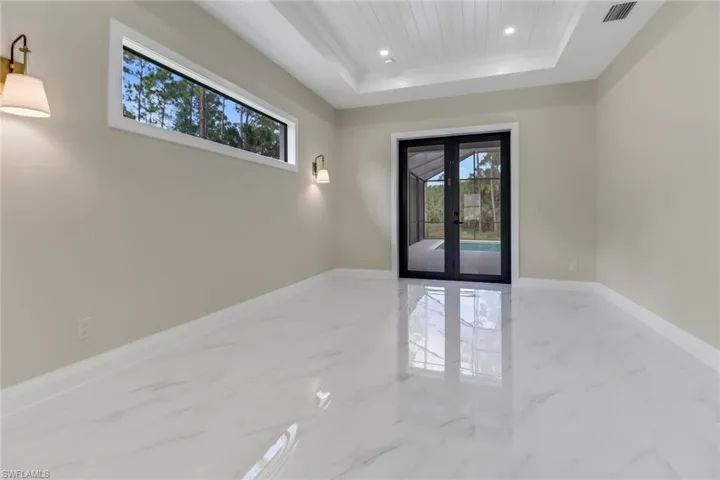 Unfurnished room featuring a tray ceiling and french doors