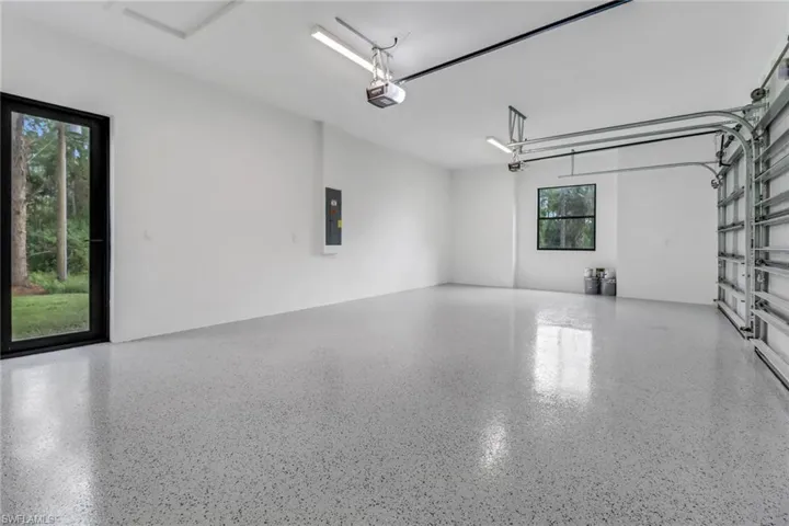 Garage featuring a garage door opener and electric panel