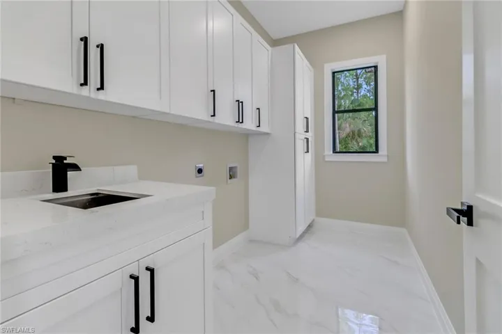 Laundry room with washer hookup, cabinets, electric dryer hookup, and sink