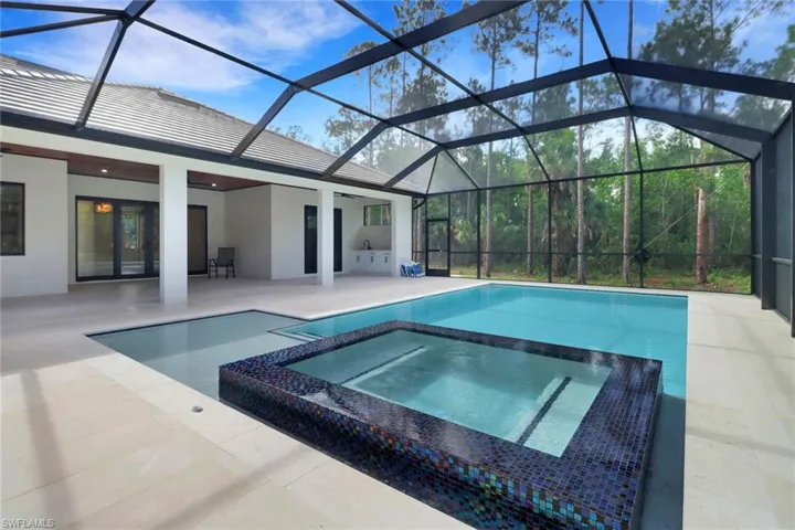 View of pool with a patio area, an in ground hot tub, and a lanai