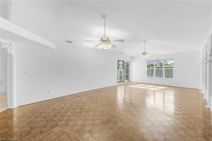 Spare room featuring ceiling fan, light parquet flooring, and lofted ceiling