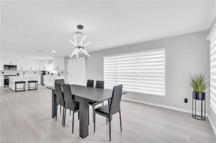 Dining room with a notable chandelier, light hardwood / wood-style floors, and sink
