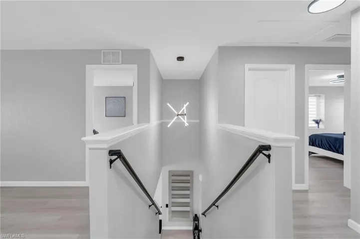Staircase featuring hardwood / wood-style floors and a notable chandelier