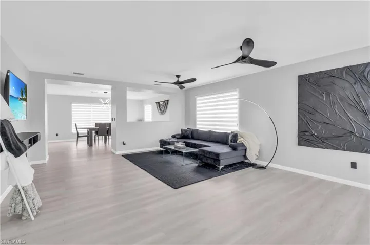 Living room with ceiling fan and light hardwood / wood-style flooring