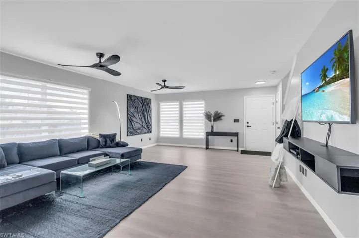 Living room with wood-type flooring and ceiling fan