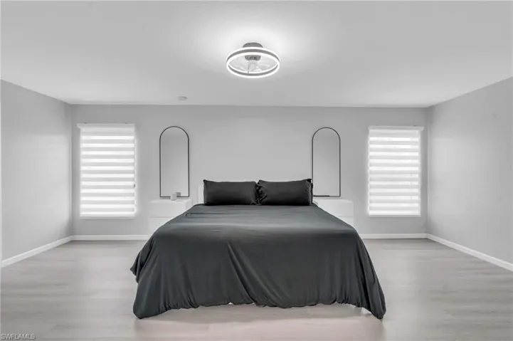 Bedroom with multiple windows and light hardwood / wood-style flooring
