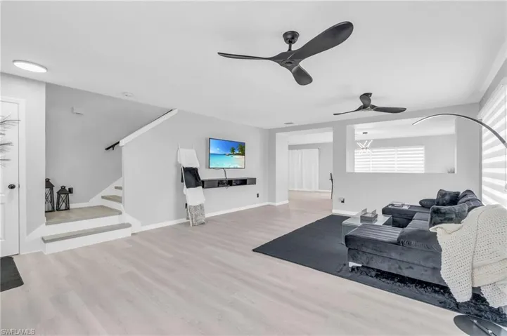 Living room with ceiling fan and light wood-type flooring