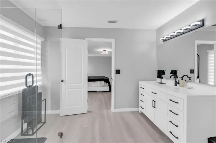 Bathroom featuring a shower with door, vanity, and hardwood / wood-style flooring
