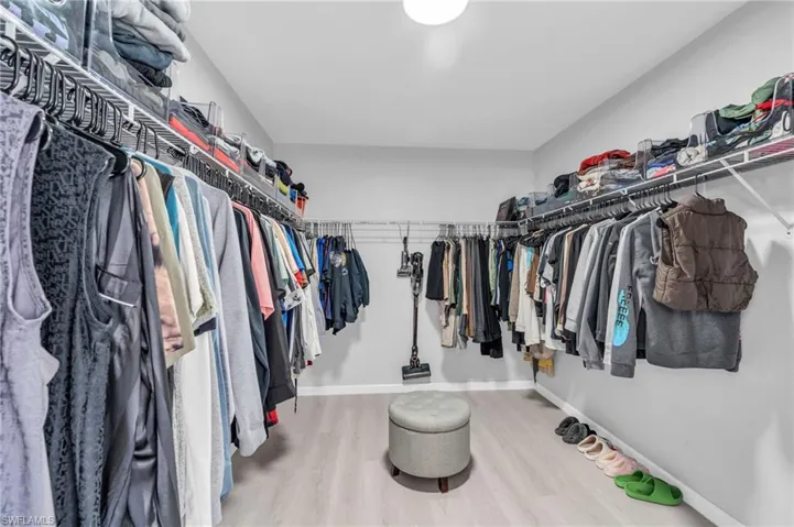 Walk in closet with wood-type flooring