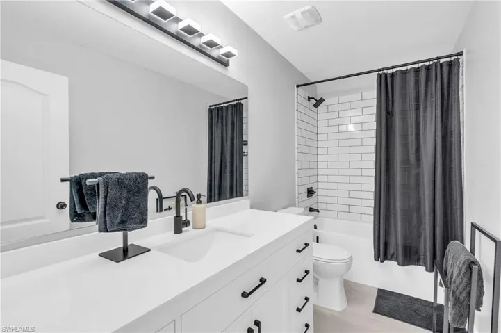 Full bathroom featuring vanity, toilet, and shower / bath combo with shower curtain