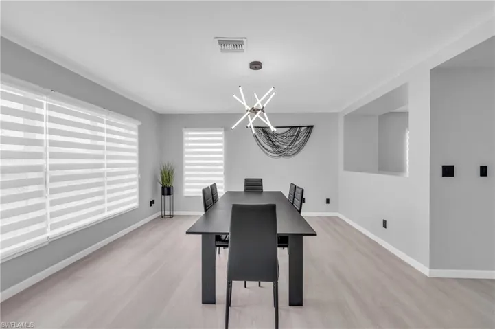 Dining room with a notable chandelier and light wood-type flooring