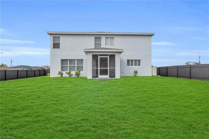 Back of property featuring a lawn and a sunroom