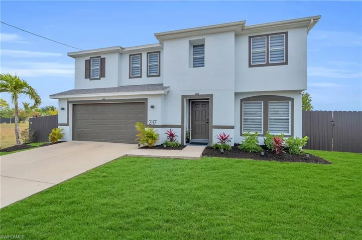 View of front facade with a garage and a front lawn