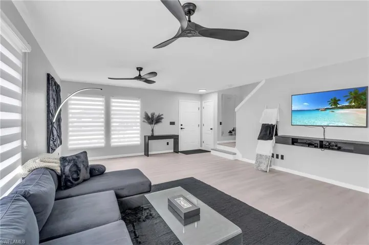 Living room with ceiling fan and light hardwood / wood-style floors
