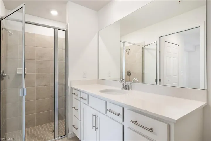 Bathroom featuring an enclosed shower and vanity