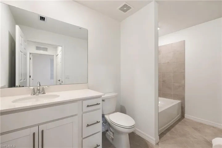 Full bathroom featuring tile flooring, vanity, toilet, and shower / tub combination