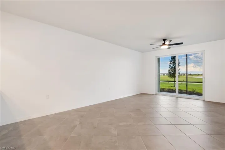 Spare room featuring ceiling fan and light tile floors