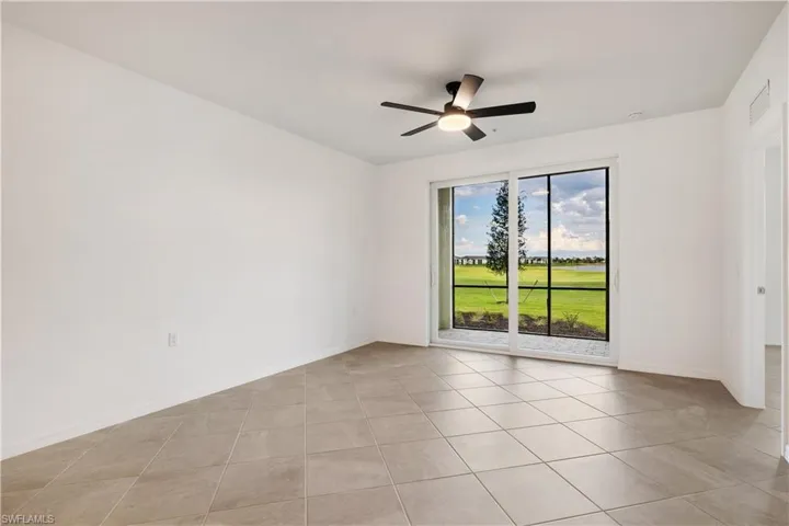 Spare room with ceiling fan and light tile flooring